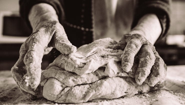 Donna anziana impasta il pane