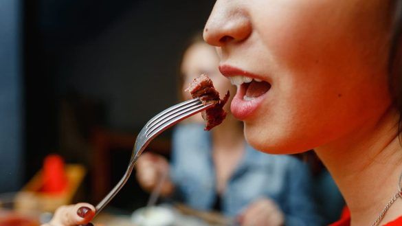 Donna che mangia la carne