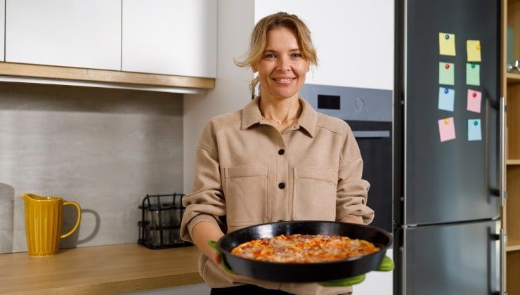 Donna mostra pizza appena sfornata