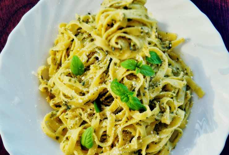 Un piatto di pasta con basilico