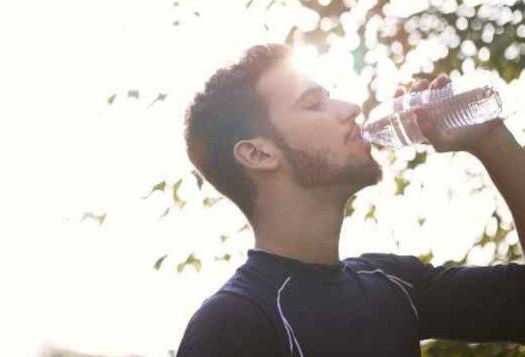 Un uomo che beve acqua