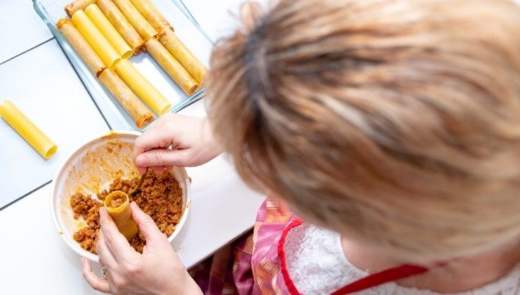 Donna prepara cannelloni alla carne