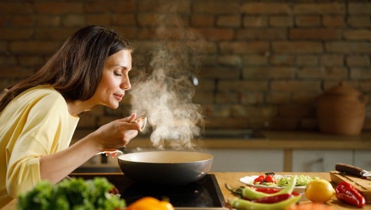 Donna sperimenta ricette in cucina