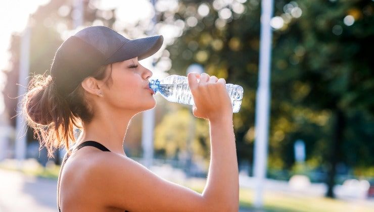 Giovane donna beve acqua potabile