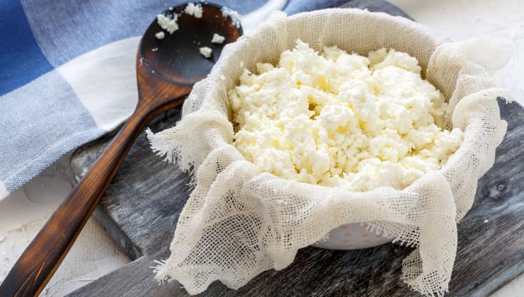 Ricotta fresca con l'aceto nel latte bollente