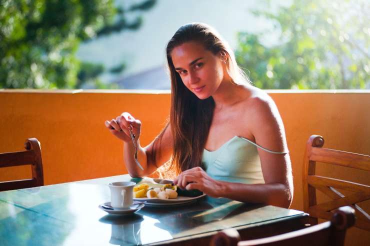 Una donna che fa colazione al bar