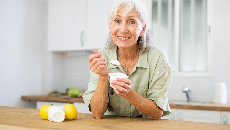 Donna matura mangia yogurt