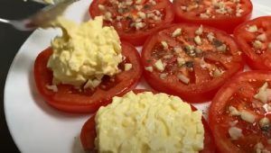 Fette di pomodori condite con uova e maionese