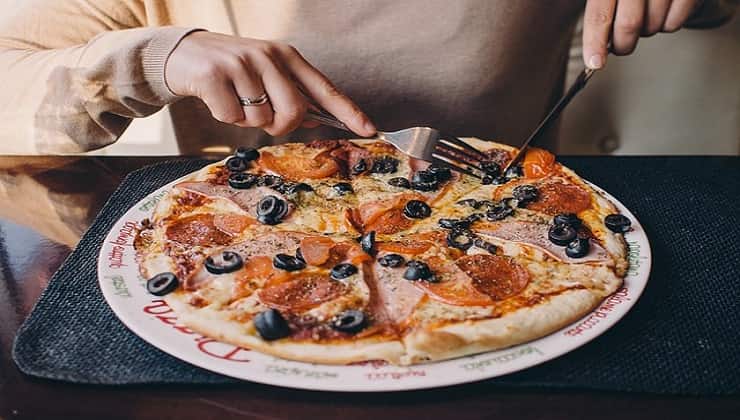 Tagliare la pizza con forchetta e coltello