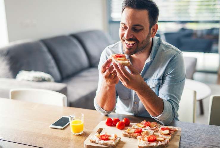 Uomo mangia formaggio e pomodori