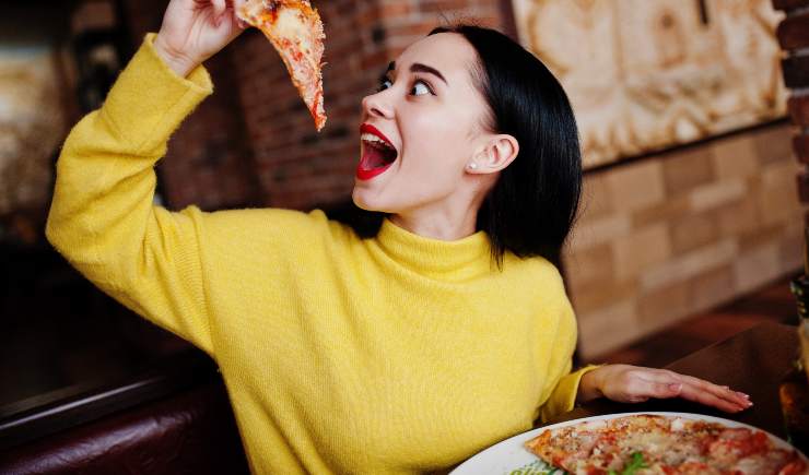 Una persona che mangia la pizza