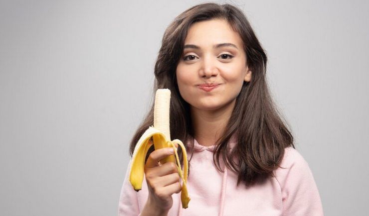 Una bambina che mangia la banana