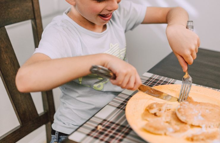 Bimbo felice di mangiare i pancake