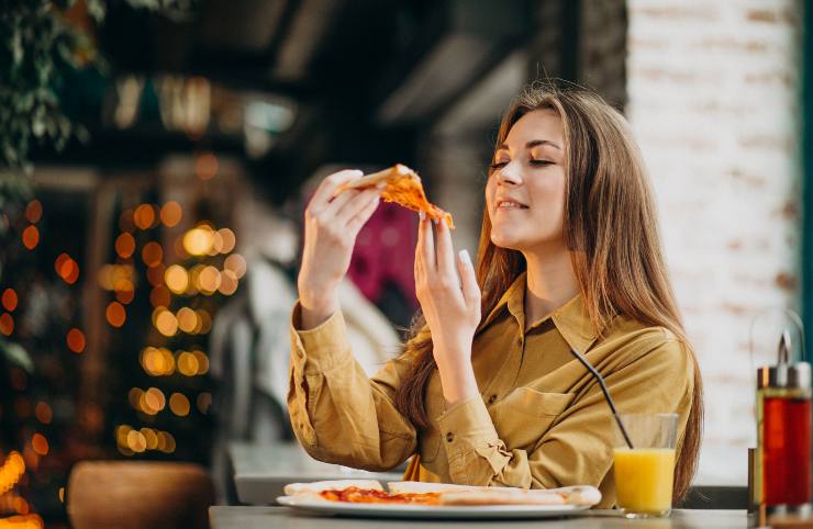 Una persona che mangia la pizza