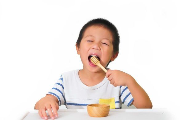 Bambino che mangia miele