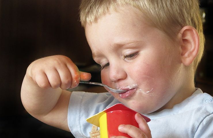 Bambino che mangia yogurt
