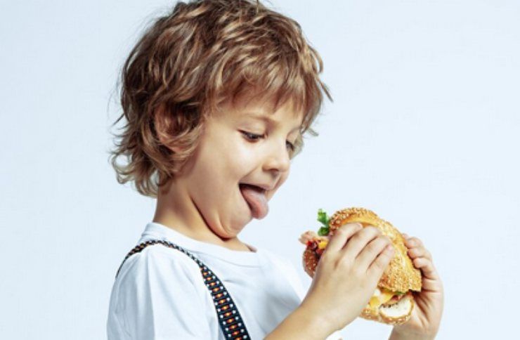 Un bambino che mangia l'hamburger
