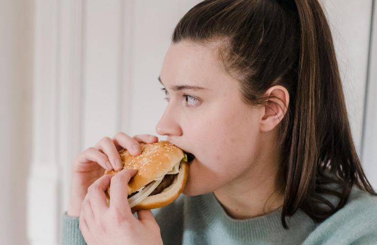Una donna che mangia un hamburger