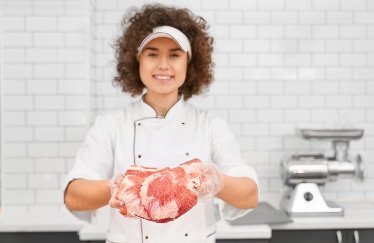 Una donna che tiene in mano un pezzo di carne