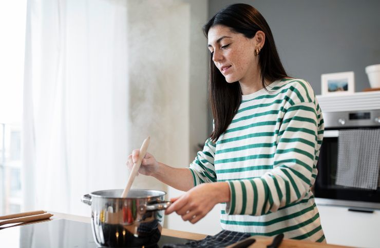 Una donna che cucina la minestra